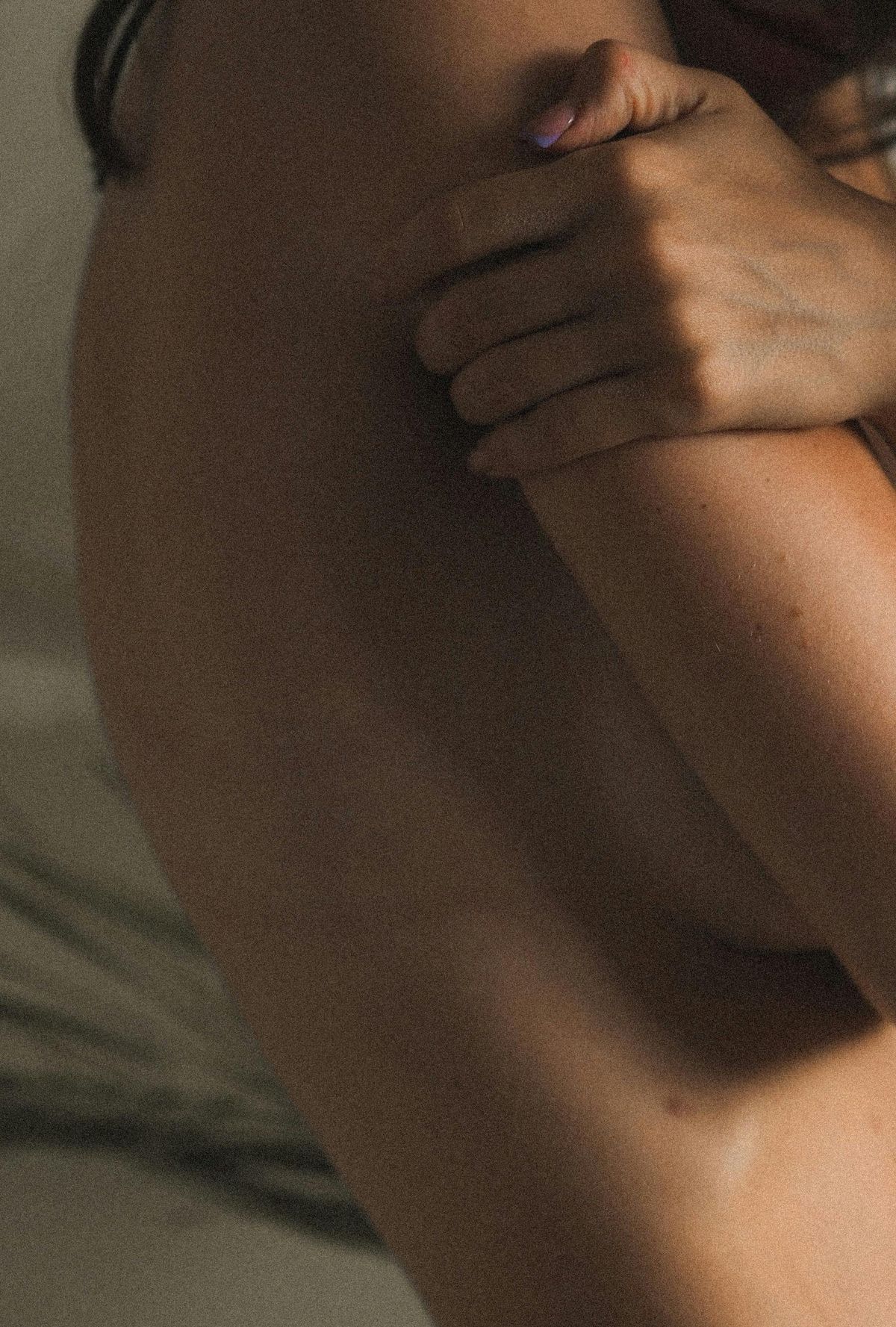 Mulher a abraçar-se a si própria, em luz quente