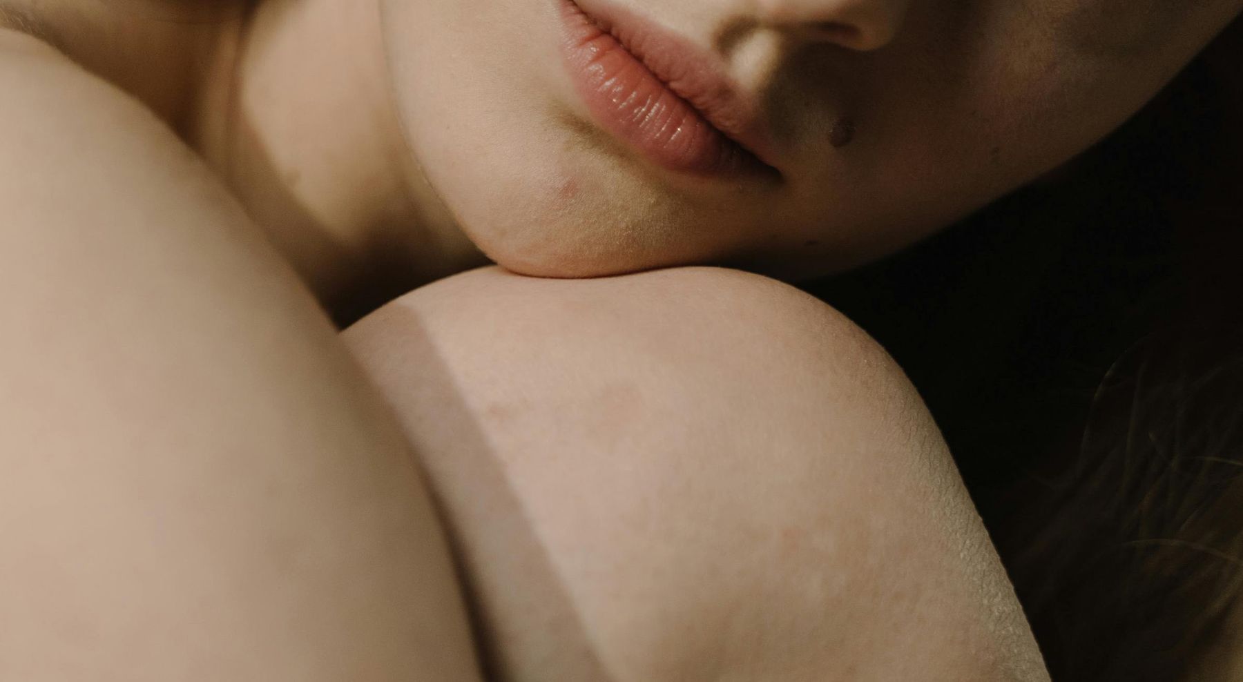 Lábios naturais de mulher apoiados no ombro